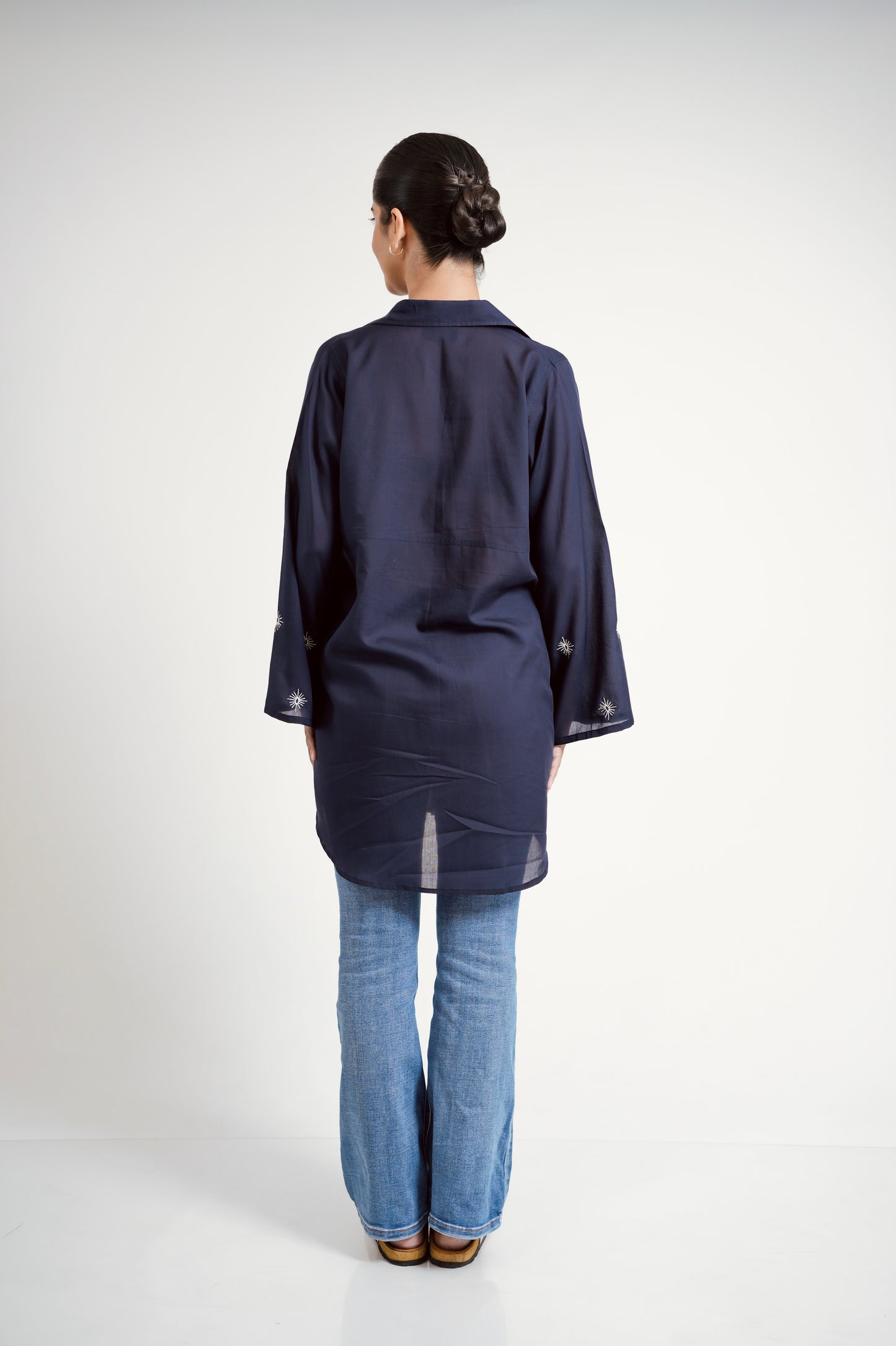 Person wearing a navy blue kimono-style garment on a white background